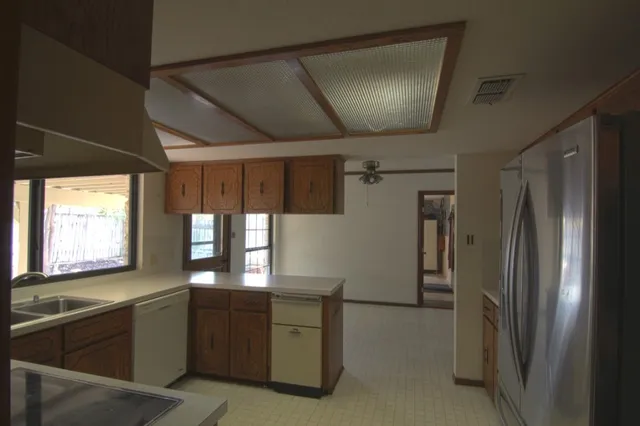 a kitchen with kitchen island a counter top space cabinets and stainless steel appliances