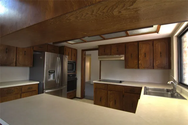 an empty room with windows and ceiling fan