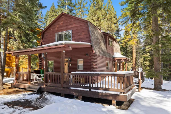 a view of a house with a wooden deck and a yard