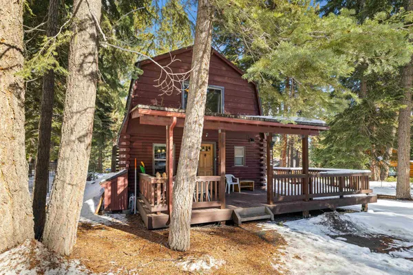 a view of a house with a yard chairs and wooden fence