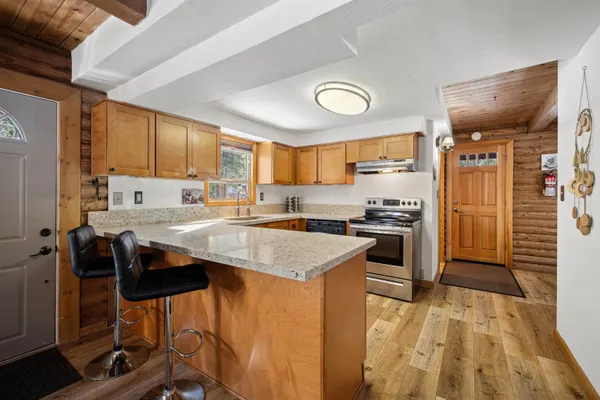a kitchen with a sink a stove cabinets and a dining table