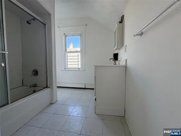 a bathroom with a tub shower and sink