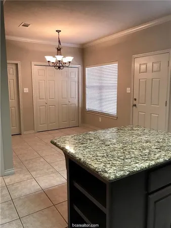 a view of kitchen island with granite countertop furniture and chandelier