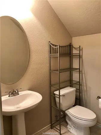 a bathroom with a sink toilet mirror and shower