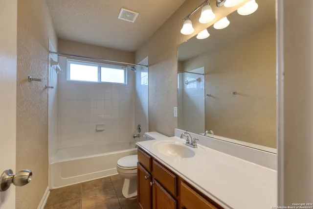 a bathroom with a sink a toilet a mirror and shower