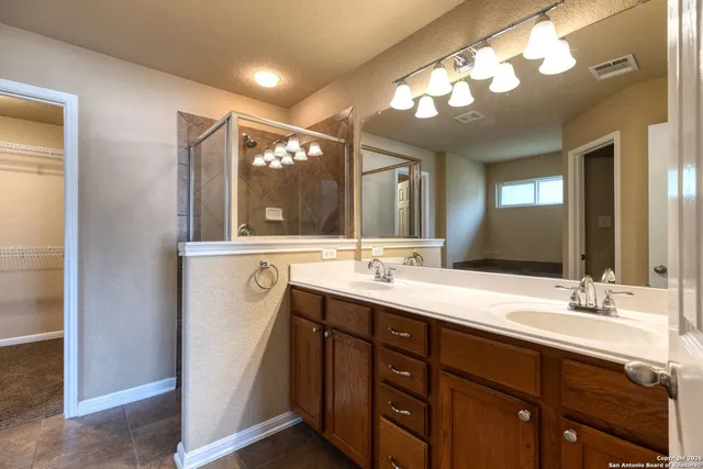 a bathroom with a double vanity sink and a mirror