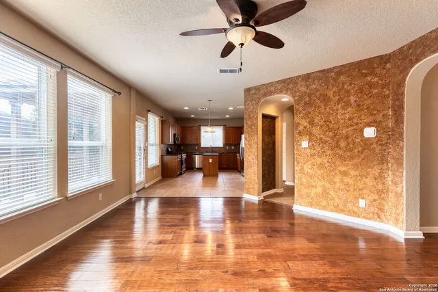 a view of a living room with a floor to ceiling window and wooden floor