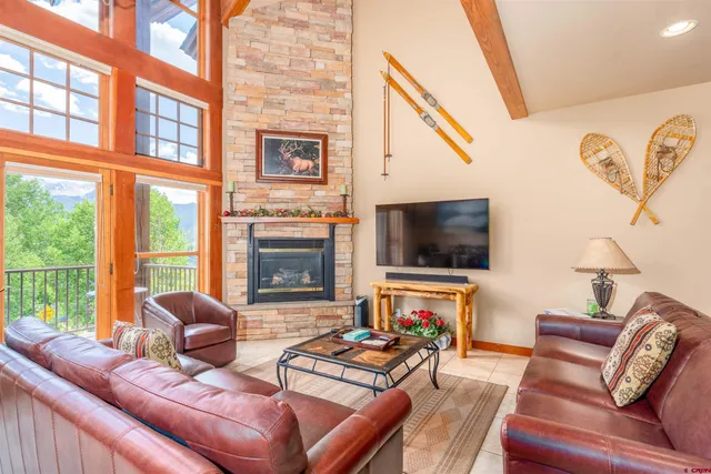 a living room with furniture a flat screen tv and a floor to ceiling window
