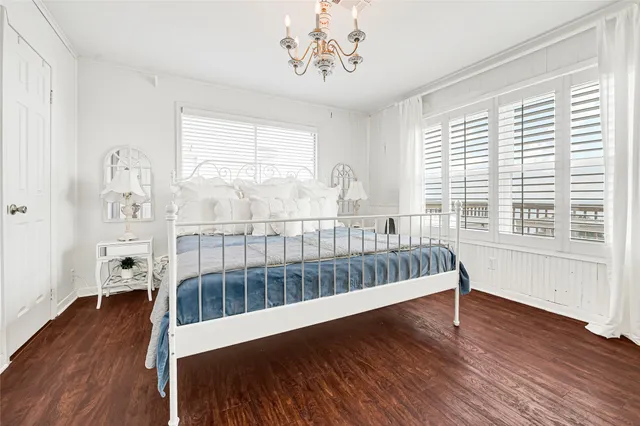a view of bedroom with wooden floor and windows