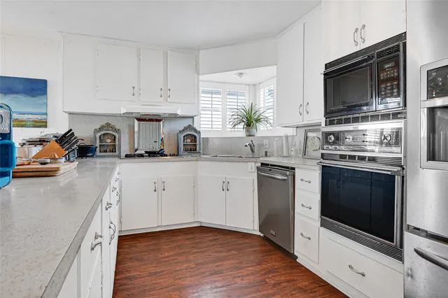 a kitchen with white cabinets stainless steel appliances and sink