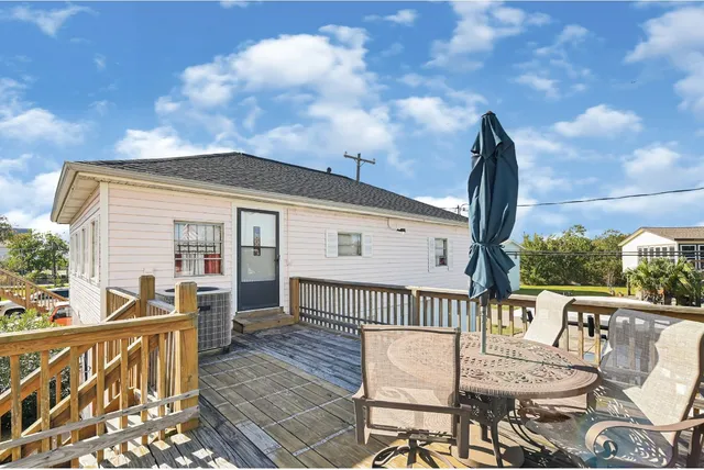 a view of a house with wooden deck and furniture