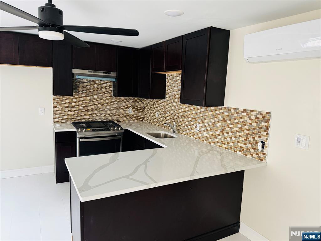 a kitchen with stainless steel appliances kitchen island a sink dishwasher a refrigerator and wooden cabinets