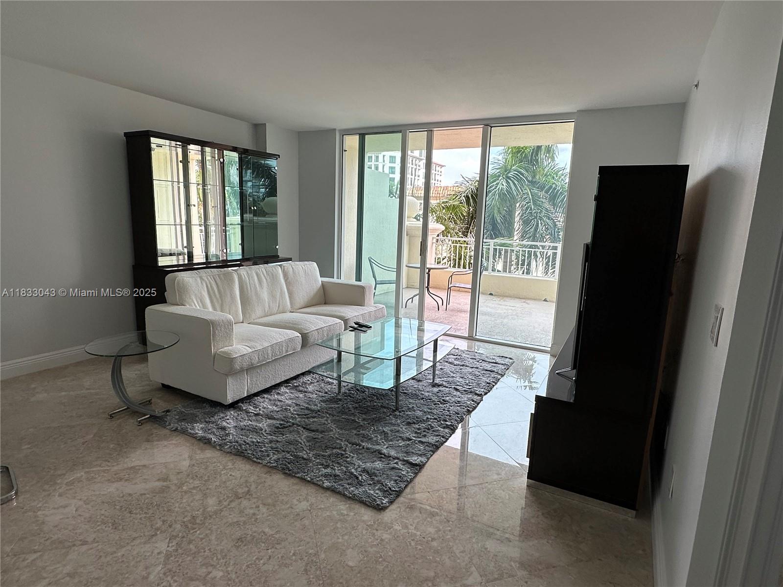 99 Southeast Mizner Boulevard, Unit 313 Boca Raton, FL 33432 - Photo 2 of 8 a living room with furniture and a floor to ceiling window