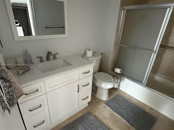 a bathroom with a granite countertop toilet sink and a mirror