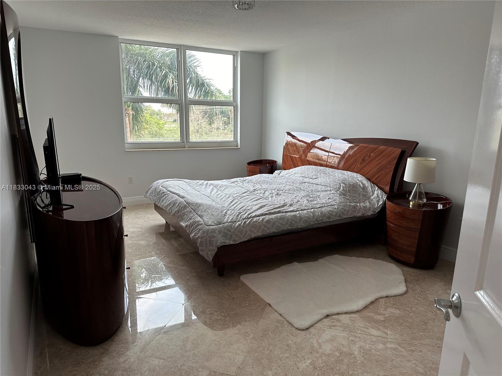 99 Southeast Mizner Boulevard, Unit 313 Boca Raton, FL 33432 - Photo 5 of 8 a bedroom with a bed and a window