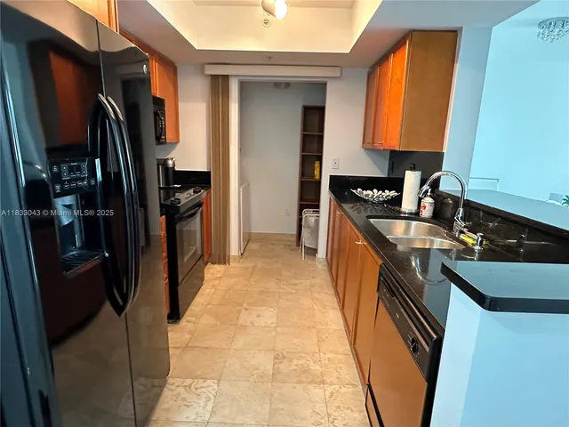 a kitchen with stainless steel appliances granite countertop a refrigerator and a sink