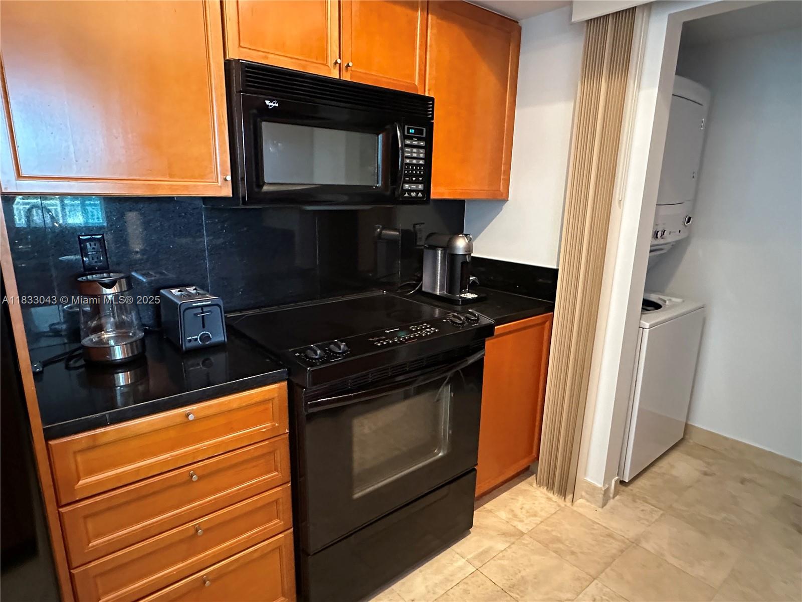 99 Southeast Mizner Boulevard, Unit 313 Boca Raton, FL 33432 - Photo 7 of 8 a kitchen with a stove and a microwave