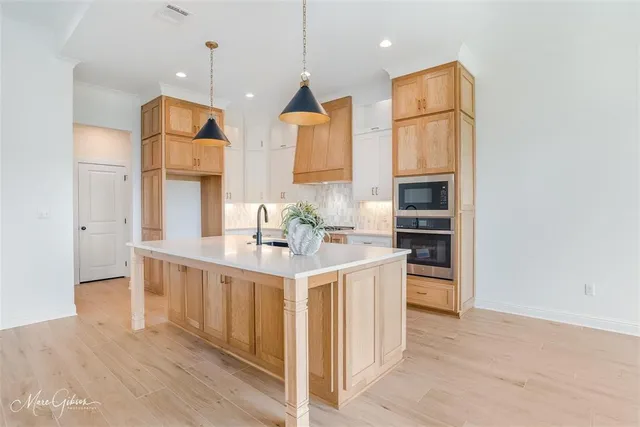 a kitchen with stainless steel appliances granite countertop a sink a stove and a refrigerator