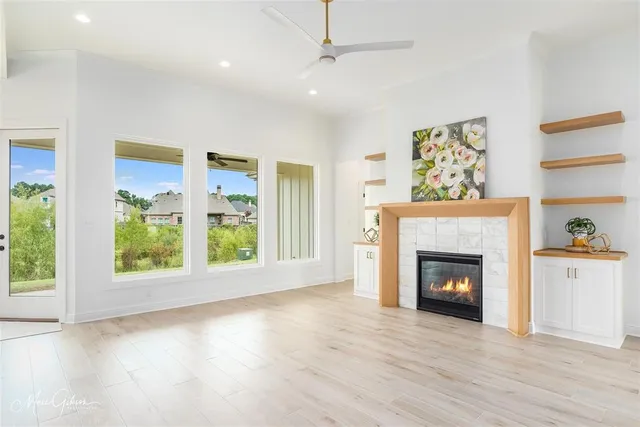 a view of an empty room with a window and fireplace