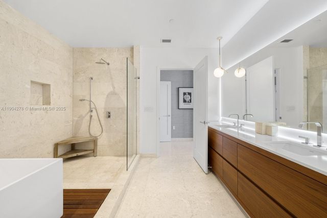 a spacious bathroom with a double vanity sink a mirror and a shower