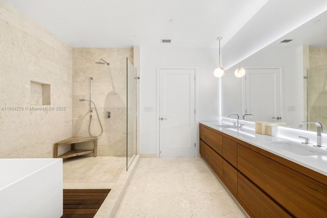 a bathroom with a double vanity sink a toilet and a tub