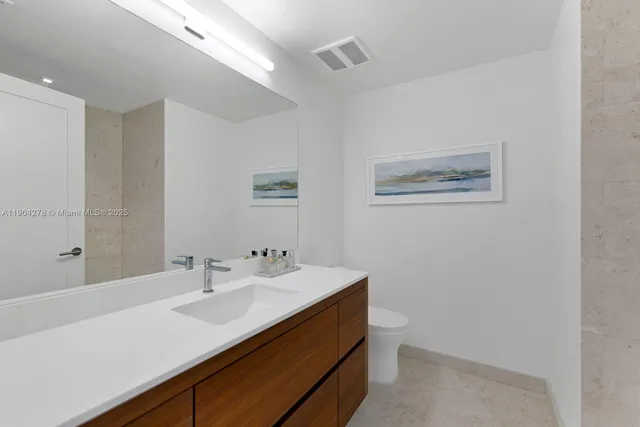 a bathroom with a sink mirror vanity and toilet