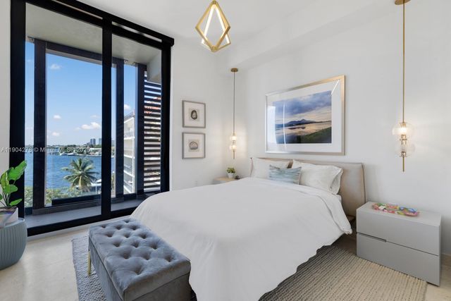 a bedroom with a bed and a large window with outer view