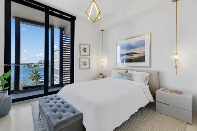 a bedroom with a bed and a large window with outer view