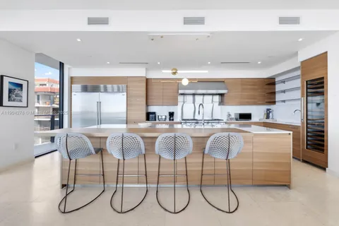 a kitchen with stainless steel appliances granite countertop a table chairs sink and cabinets