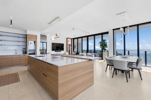 a large white kitchen with a large window and stainless steel appliances