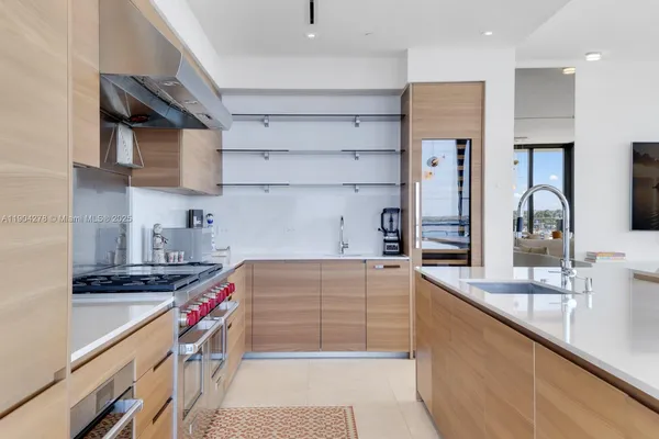a kitchen with kitchen island a sink stove and cabinets