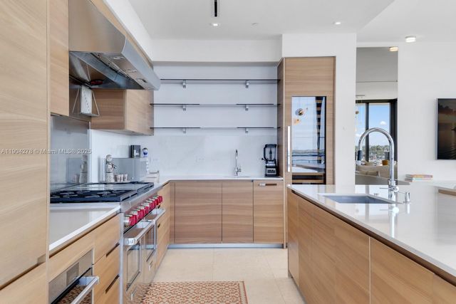 a kitchen with kitchen island a sink stove and cabinets
