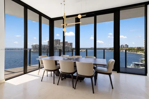 a dining room with furniture and a floor to ceiling window