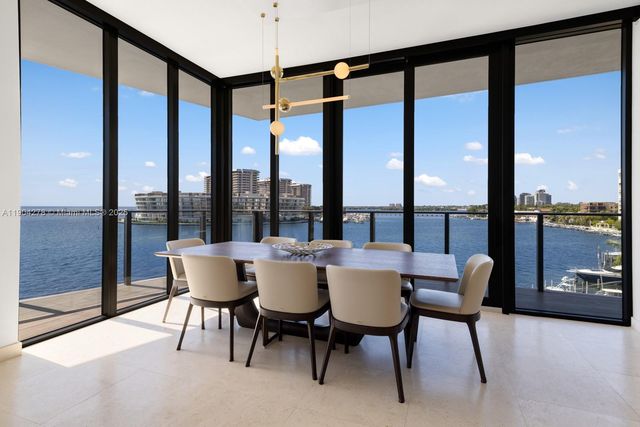 a dining room with furniture and a floor to ceiling window