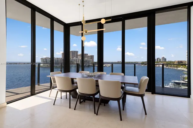a dining room with furniture and a floor to ceiling window