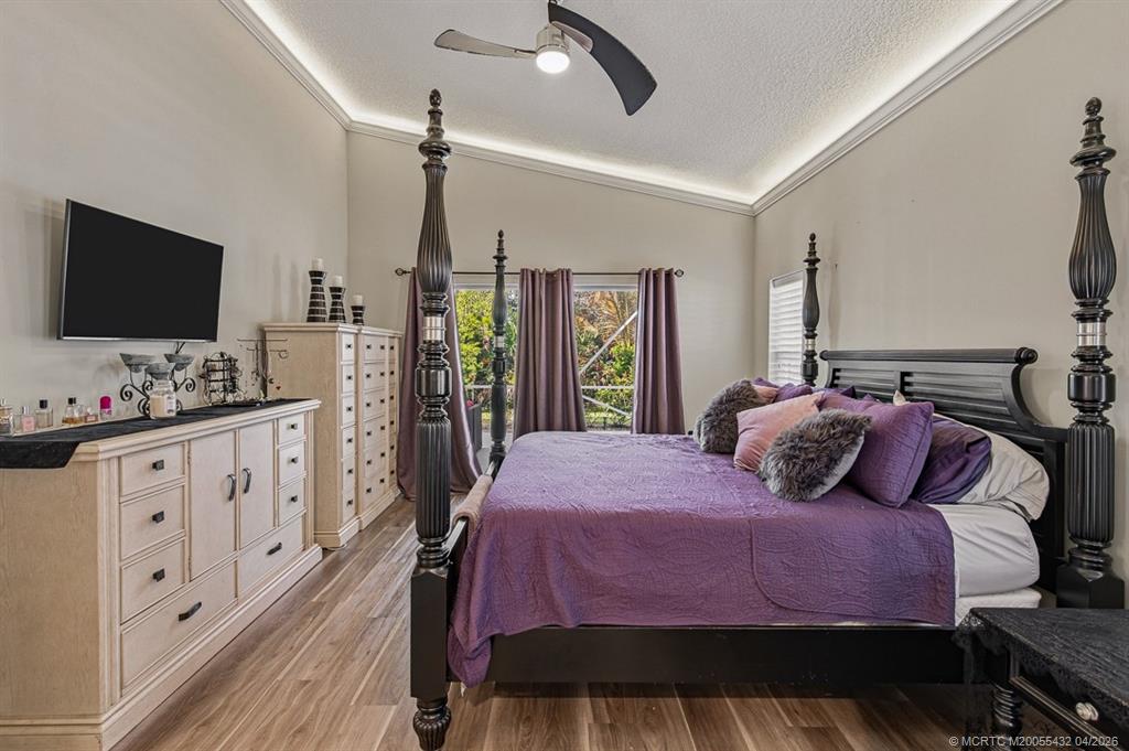 7213 Southeast Magellan Lane Stuart, FL 34997 - Photo 19 of 47 a bedroom with a large bed and a flat tv screen on dresser