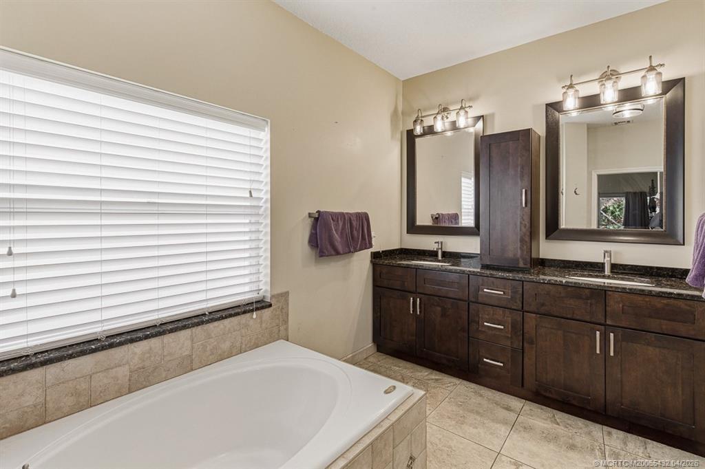 7213 Southeast Magellan Lane Stuart, FL 34997 - Photo 21 of 47 a bathroom with a sink vanity and mirror