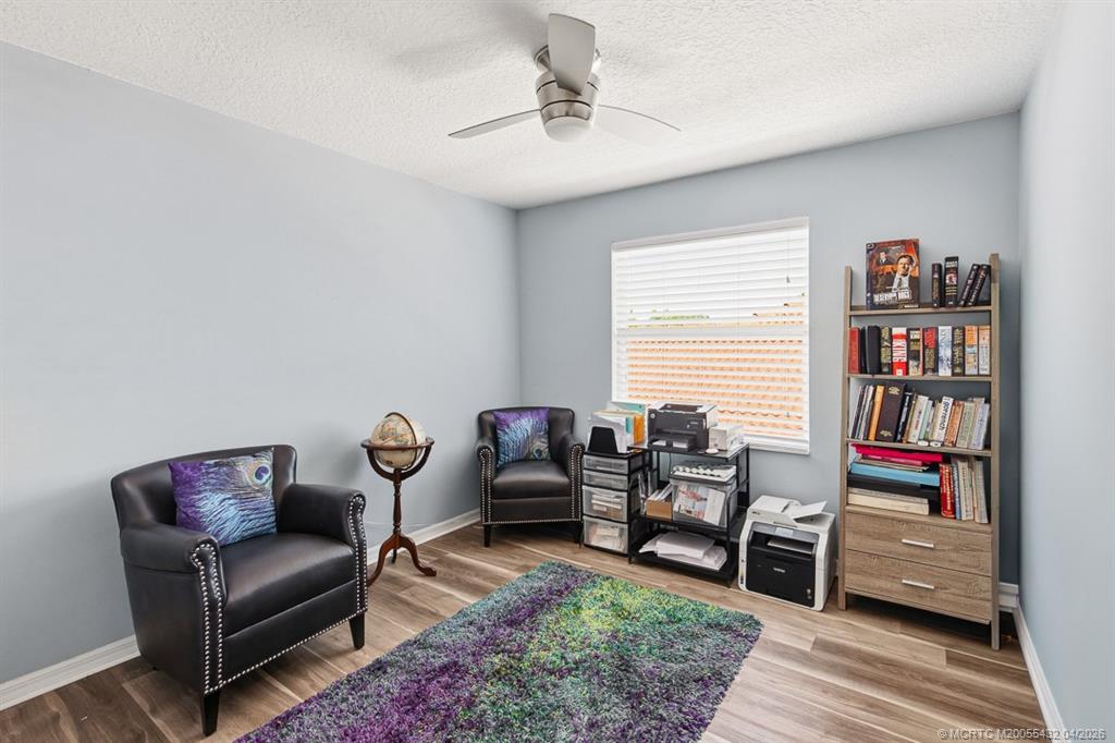 7213 Southeast Magellan Lane Stuart, FL 34997 - Photo 34 of 47 a living room with furniture and a book shelf