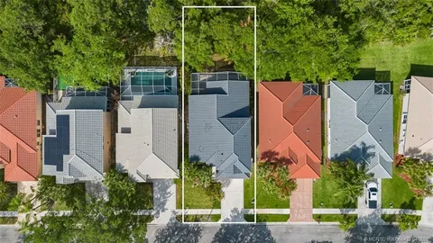 an aerial view of a house with a yard and large trees