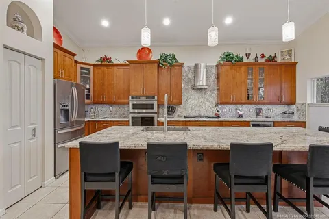 a kitchen with stainless steel appliances granite countertop table chairs sink and cabinets