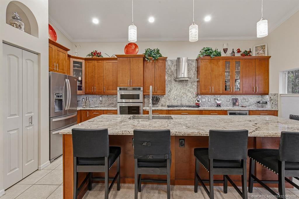 7213 Southeast Magellan Lane Stuart, FL 34997 - Photo 10 of 47 a kitchen with stainless steel appliances granite countertop table chairs sink and cabinets