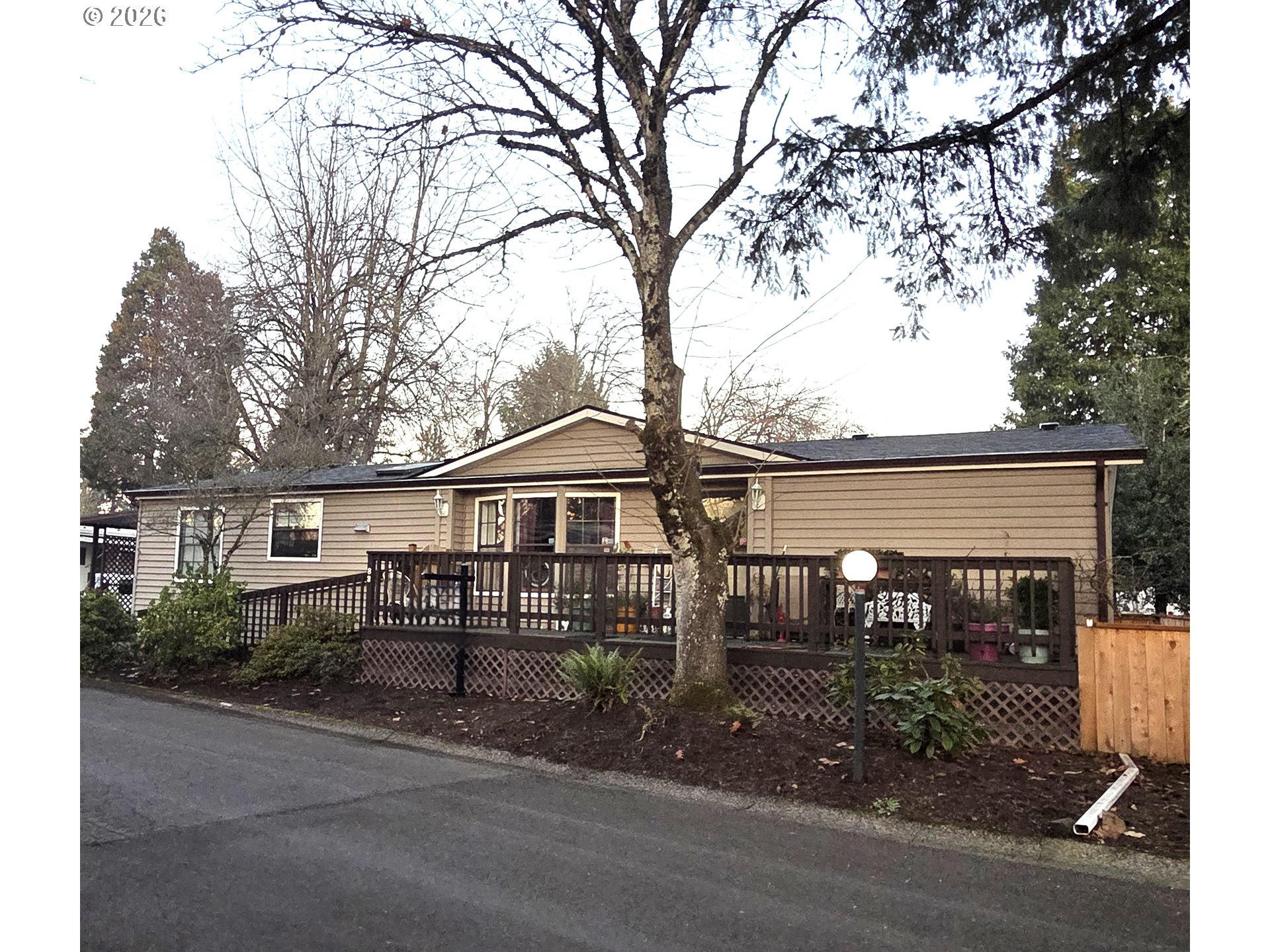1475 Green Acres Road, Unit 83 Eugene, OR 97408 - Photo 25 of 37 front view of a house with a bench and large trees