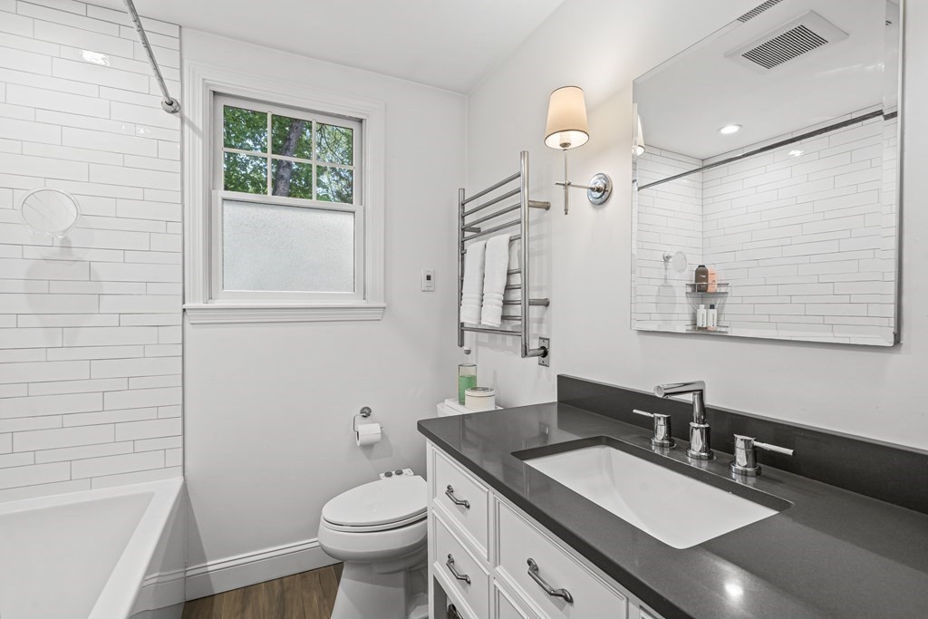 229 Weston Road Wellesley, MA 02482 - Photo 17 of 24 a bathroom with a granite countertop sink a toilet a mirror and shower