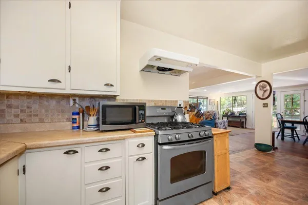 a kitchen with stainless steel appliances granite countertop a stove a sink and a white cabinets