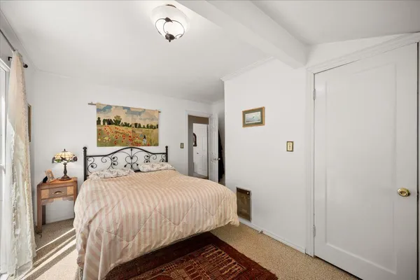 a bedroom with a bed and a large window