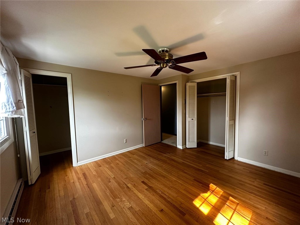 2093 Cambridge Road Coshocton, OH 43812 - Photo 23 of 32 Unfurnished bedroom featuring wood-type flooring, baseboard heating, and ceiling fan