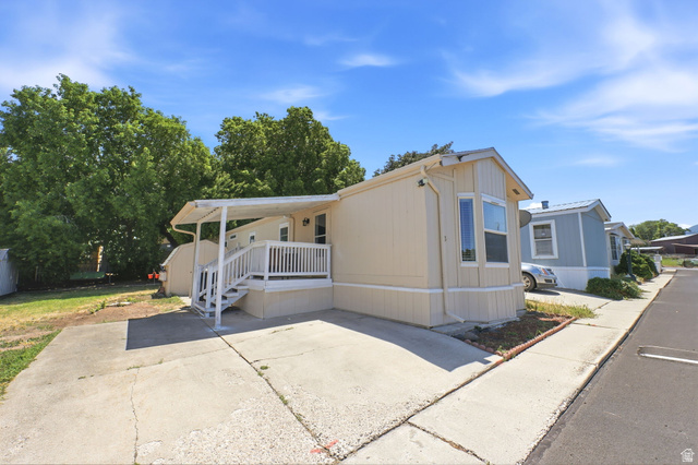 1525 South 400 East, Unit 13 Springville, UT 84663 - Photo 8 of 32 Light-colored siding exterior featuring a covered porch with white railings, a bay window, and an adjacent paved driveway