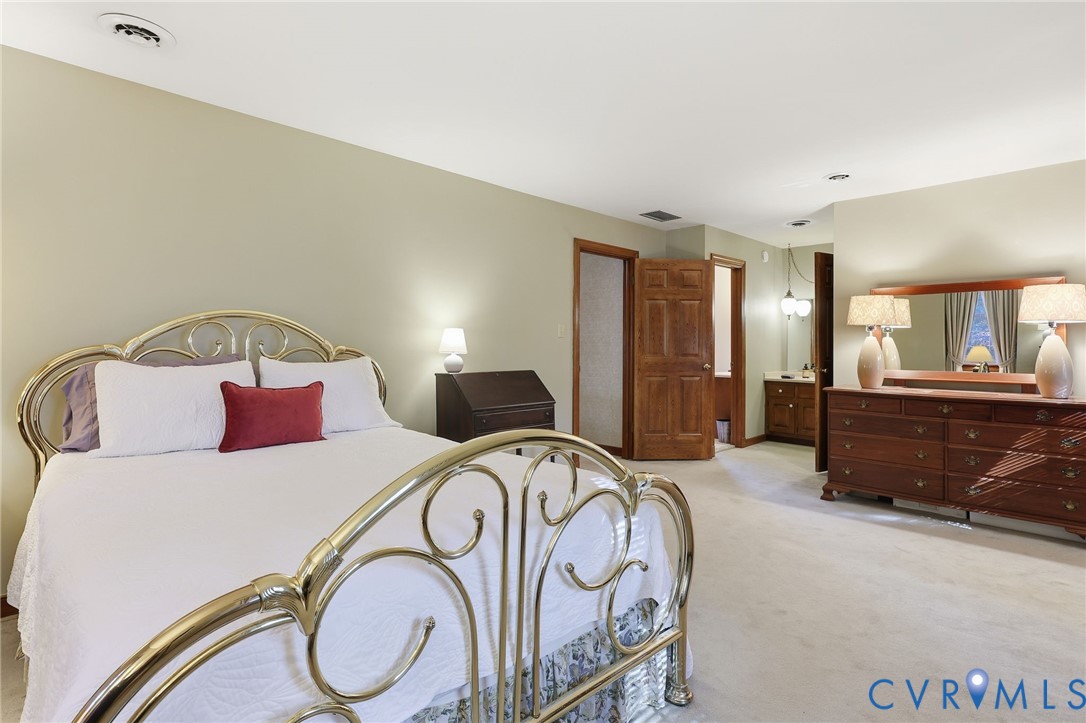 8216 Chainmaile Road North Chesterfield, VA 23235 - Photo 19 of 36 a bedroom with a large bed and a view of bathroom