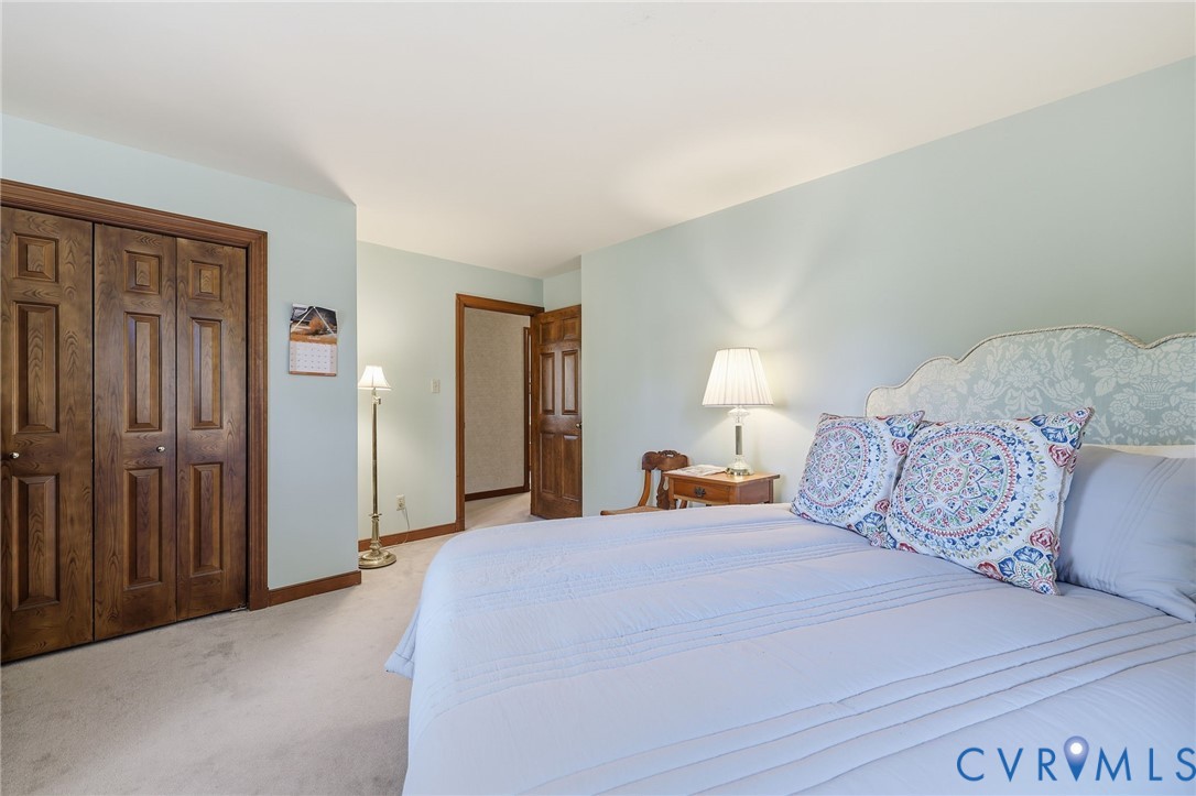 8216 Chainmaile Road North Chesterfield, VA 23235 - Photo 25 of 36 a large bedroom with a bed and a lamp