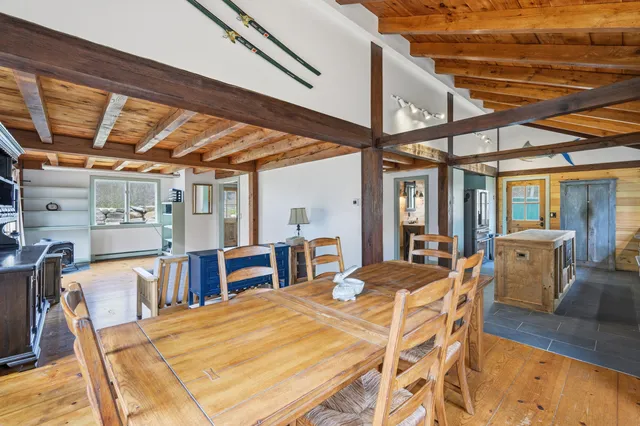 a view of an empty room with a window and hardwood floor